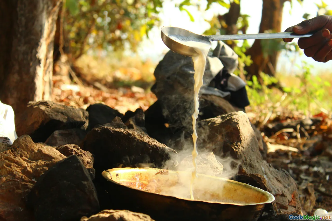 Ghanaian traditional stove, millet porridge cooking, cast iron pot